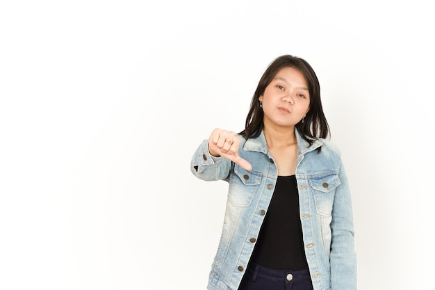 Mostrando los pulgares hacia abajo de la hermosa mujer asiática con chaqueta de jeans y camisa negra aislado en blanco