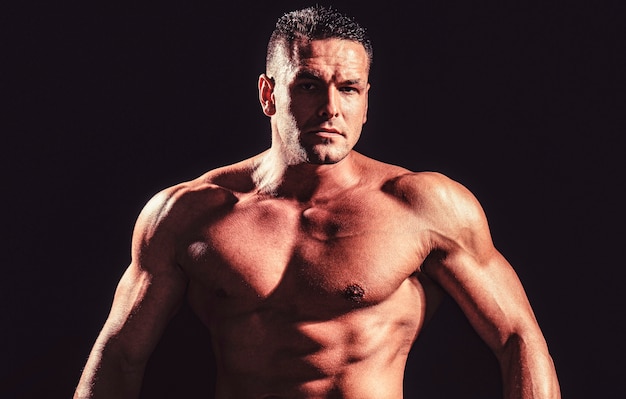 Mostrando torso muscular. Retrato de homem forte e bonito Atlético. Homem forte e atlético mostrando corpo musculoso e barriga tanquinho.