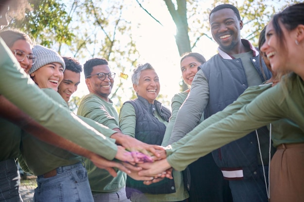 Motivação da equipe e amigos em um amontoado enquanto caminham juntos na floresta ou na floresta por baixo Exercício de fitness ou natureza com um grupo de amigos de homens e mulheres de diversidade colocando as mãos em um círculo