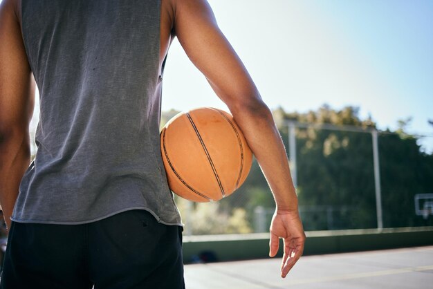 Motivação de basquete e homem segurando bola na quadra ao ar livre pronto para jogar jogo e praticar Bem-estar esportivo e homem negro em pé na quadra de basquete para treinamento físico e exercícios