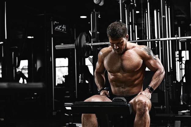 Motivación deportiva gimnasio teatro tipo musculoso culturista haciendo ejercicios con pesas en el gimnasio