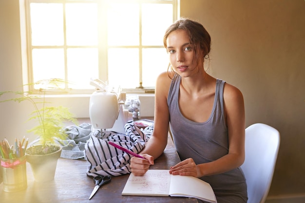 La motivación es lo que te hace empezar Una joven diseñadora confeccionando una prenda en su lugar de trabajo