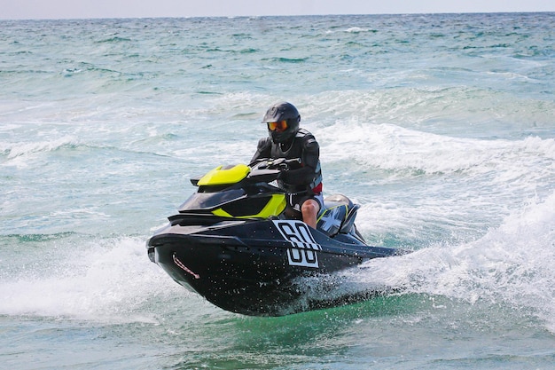 Moto de agua Joven en moto de agua Piloto de moto de agua profesional Campeonato de moto de agua Moto de agua realiza muchos trucos sobre las olas