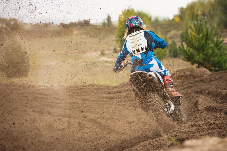 Foto moto cross mx chica motociclista en la carrera en rusia una curva aguda y el rociado de tierra vista trasera