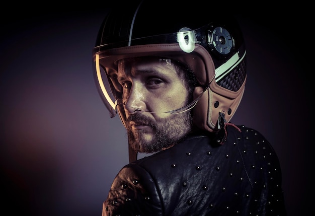 Moto, motociclista com capacete de moto e jaqueta de couro preta, tachas de metal