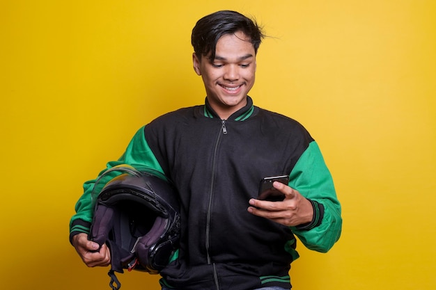 Moto de taxista en línea asiática con casco mientras realiza una llamada telefónica