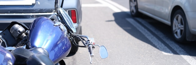 Motocicleta azul delante del coche en primer plano de la carretera