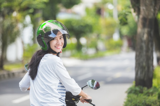 Motocicleta bonita da equitação da mulher