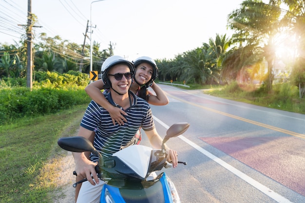 Motocicleta de equitação de casal feliz no campo excited mulher e homem viajam na viagem de moto