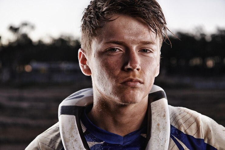 Foto motocicleta de terra esportiva e retrato de um homem em offroad em equipamento para desafio de corrida ou competição aventura séria e rosto de motociclista atleta masculino com lama em ação motocross rally ao ar livre