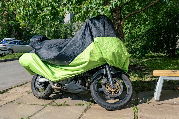 Motocicleta en el estacionamiento en el patio cubierto con una cubierta de lluvia