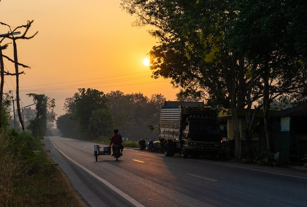 Motocicleta na estrada de asfalto no campo e manhã de sol