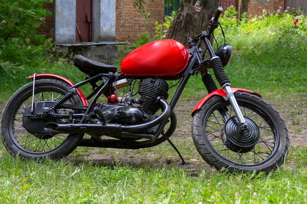 Foto motocicleta personalizada roja sobre hierba verde