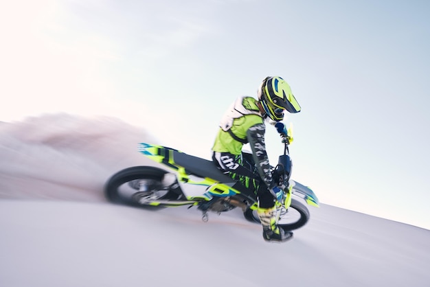 Motocicleta poeira e velocidade com um esportista montando um veículo no deserto para aventura ou adrenalina Treinamento de motocicleta e liberdade com um atleta na areia na natureza para poder ou competição ativa