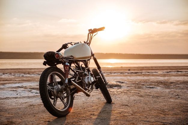 Motocicleta retro de pie en el desierto al atardecer