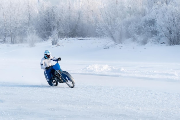 Motocicleta sobre neumáticos con clavos. Carrera ciclista extrema en invierno. motocicleta sobre el hielo del lago Baikal helado. Corredor sobre hielo. Motocicleta con neumáticos con clavos conduciendo por el lago congelado. Deportes extremos de invierno