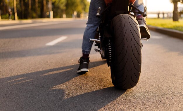 Motocicleta de temporada de verano en la carretera La goma protectora de la rueda trasera es nueva Un hombre ciclista