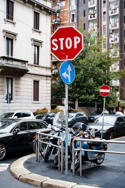 Motocicletas estacionadas en la esquina de la calle cerca de la señal de stop milán italia