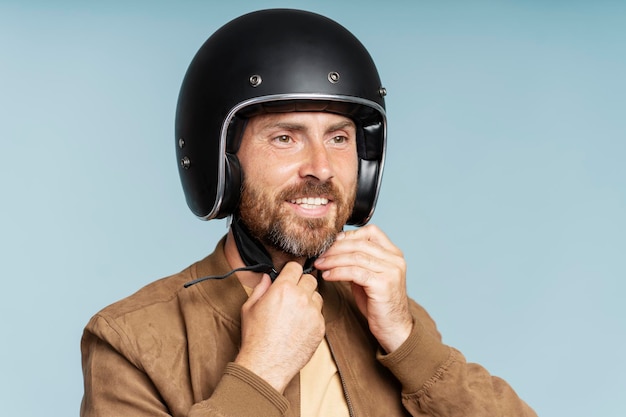 Foto motociclista con casco de motocicleta listo para montar motocicleta aislado en fondo azul