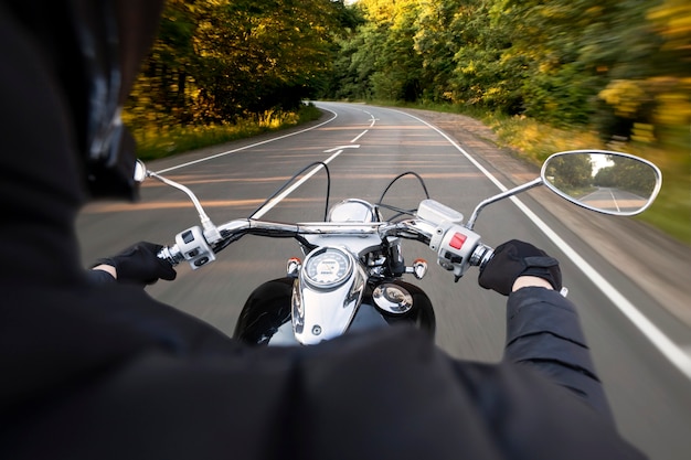 El motociclista circula por la carretera de asfalto vacía por la noche