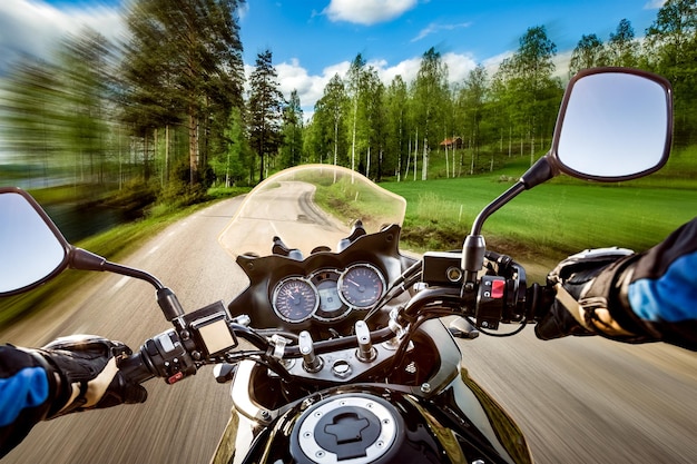 Motociclista dirigindo uma motocicleta anda pela estrada de asfalto. Visão em primeira pessoa.