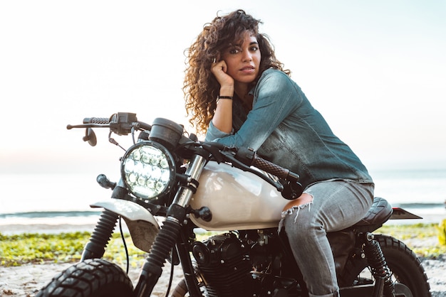 Motociclista feminina dirigindo uma moto de café piloto