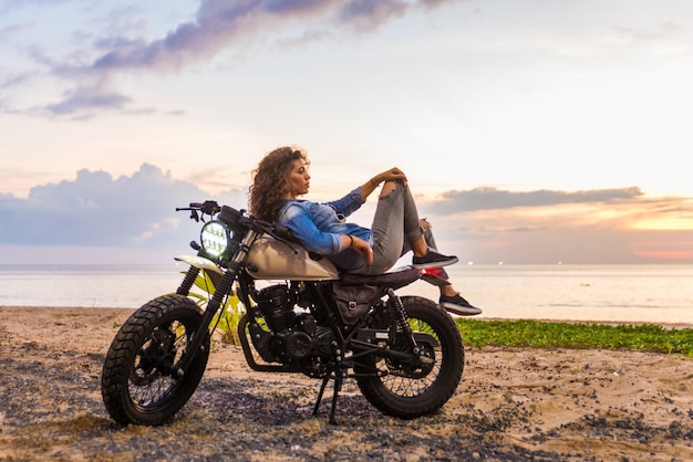 Motociclista feminina dirigindo uma moto de café piloto