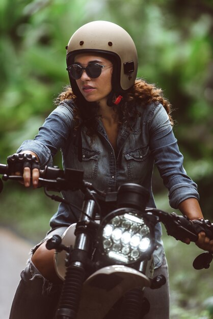 Motociclista feminina dirigindo uma moto de café piloto