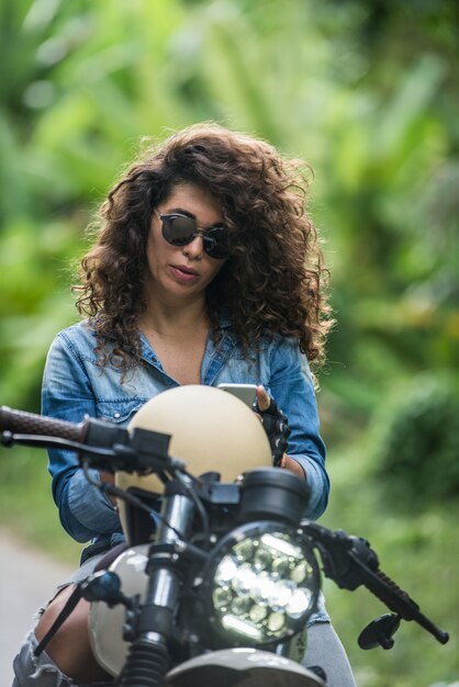 Motociclista feminina dirigindo uma moto de café piloto