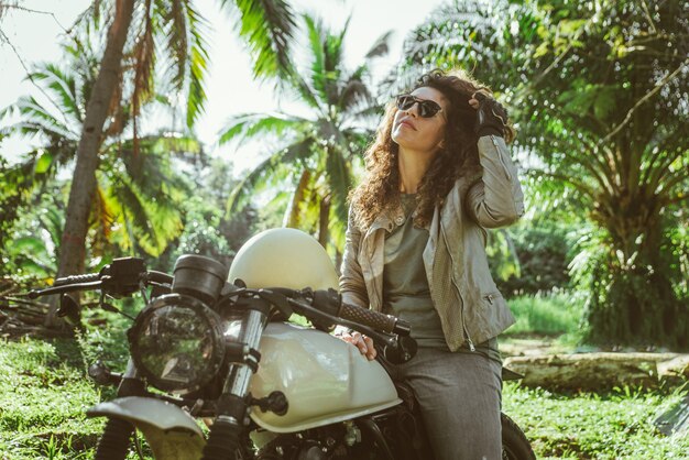 Foto motociclista feminina dirigindo uma moto de café piloto