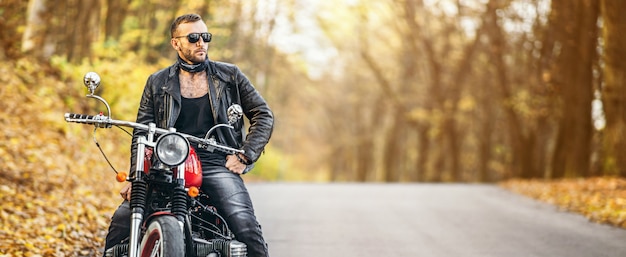 Motociclista guapo con una motocicleta roja