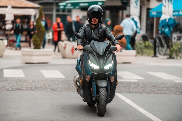 Un motociclista moderno conduce una motocicleta por la carretera de la ciudad