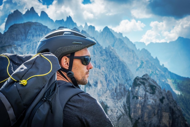 El motociclista de montaña con gafas de sol motociclista caucásico de más de 30 años disfrutando de una fantástica vista de las montañas en el sendero de los Alpes