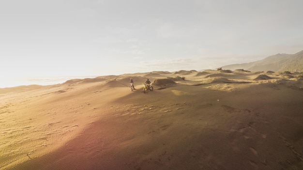 Foto motociclista en motocicleta de fondo rapido en el desierto