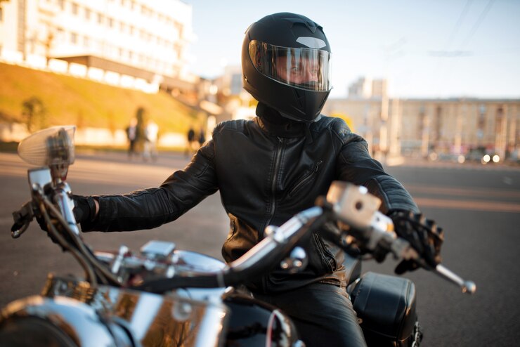 Foto motociclista na jaqueta de couro e capacete com viseira sentado no helicóptero clássico.