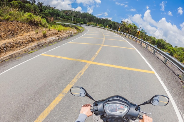 Motociclista paseos en un camino serpenteante en tiempo nublado Vietnam Dalat