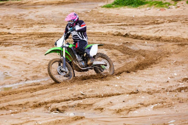 El motociclista profesional de motocross conduce sobre la pista de carretera.