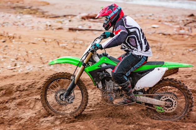 El motociclista profesional de motocross conduce sobre la pista de carretera.