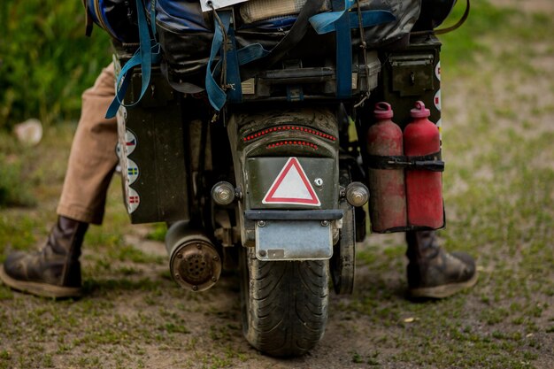 Motociclista sentado en una motocicleta en una carretera vacía vista de cerca en la rueda trasera Vista desde la tierra Concepto de transporte Una moto