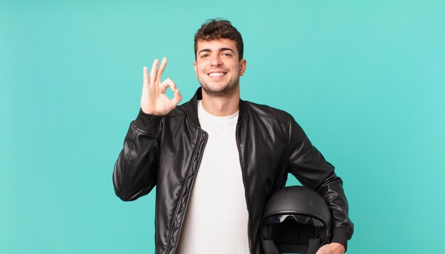 Motociclista sentindo-se feliz, relaxado e satisfeito, mostrando aprovação com gesto de ok, sorrindo