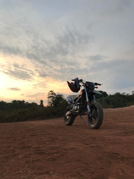 Foto motociclista supermoto com paisagem por do sol