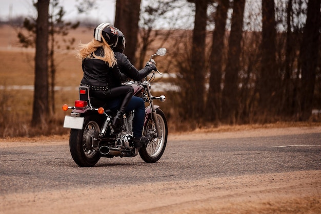 Motociclistas marido y mujer montando una motocicleta en la carretera