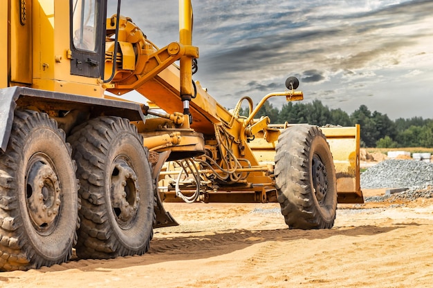 Motoniveladora de estradas no canteiro de obras Poderosa máquina de construção para nivelamento e escavação do solo Equipamento de construção profissional