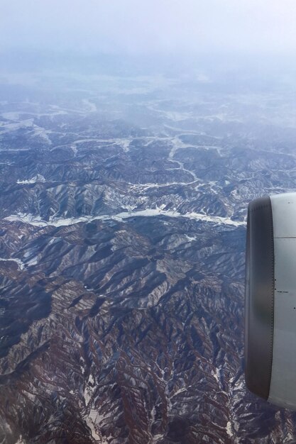 Foto motor de avión recortado volando por encima de las montañas