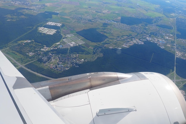 Motor de avión y vuelo de ala vista de viajes y turismo desde una ventana o vista de ojo de buey de la tierra r