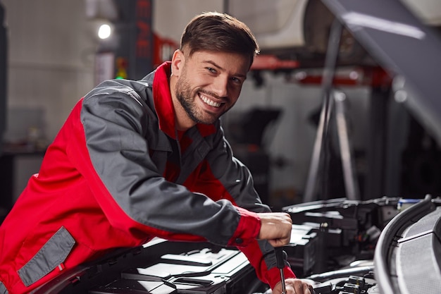 Motor de coche de fijación técnico sonriente