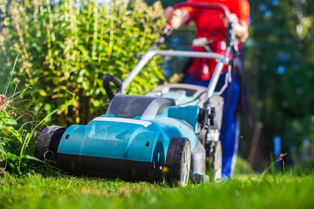 Motor do gramado na grama verde no jardim moderno ou no quintal Máquina para cortar grama Ferramentas e equipamentos de jardinagem