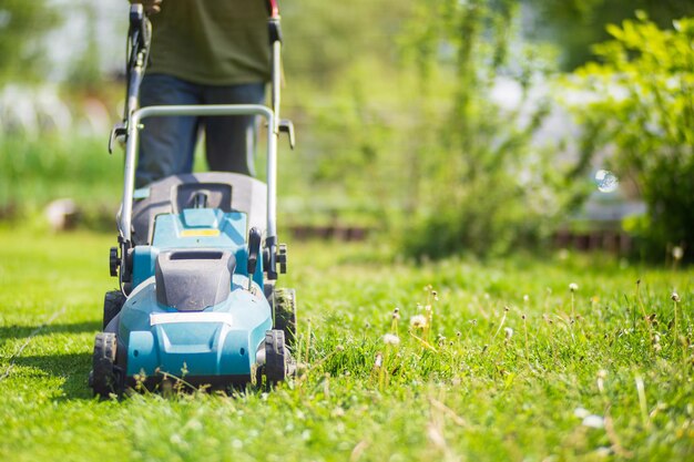 Motor do gramado na grama verde no jardim moderno ou no quintal Máquina para cortar grama Ferramentas e equipamentos de jardinagem