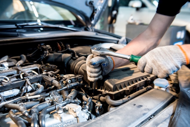 Motor de reparación de mecánico de automóviles en la estación de servicio