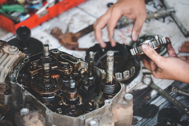 Motores de motocicleta trabalhando reparados por um mecânico em serviço de reparo de garagem